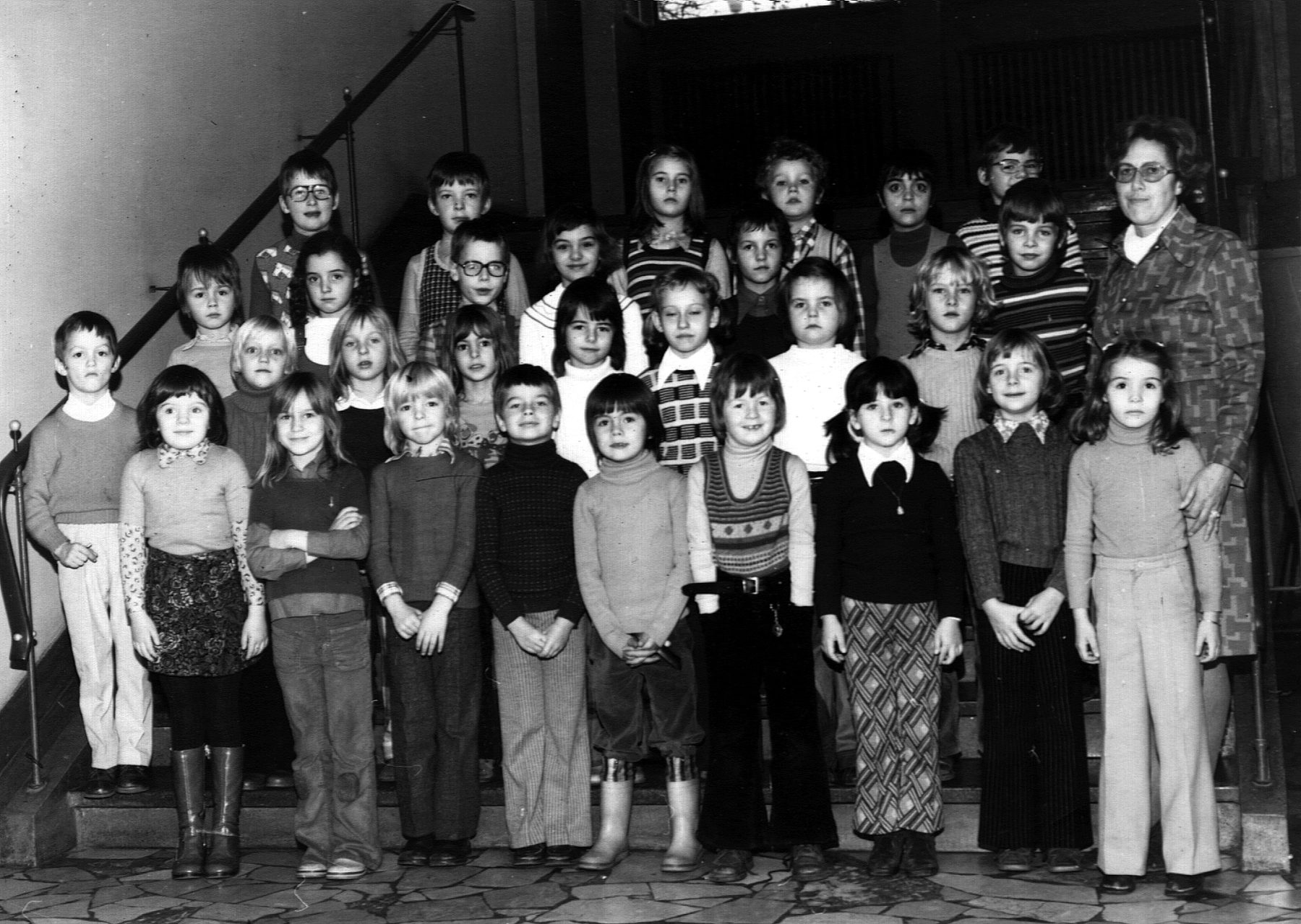 Klassenfoto 1974: die Klasse Minninger der Grundschule Saarbrücken-Ost auf einer Treppe im Schulhaus, rechts die Lehrerin